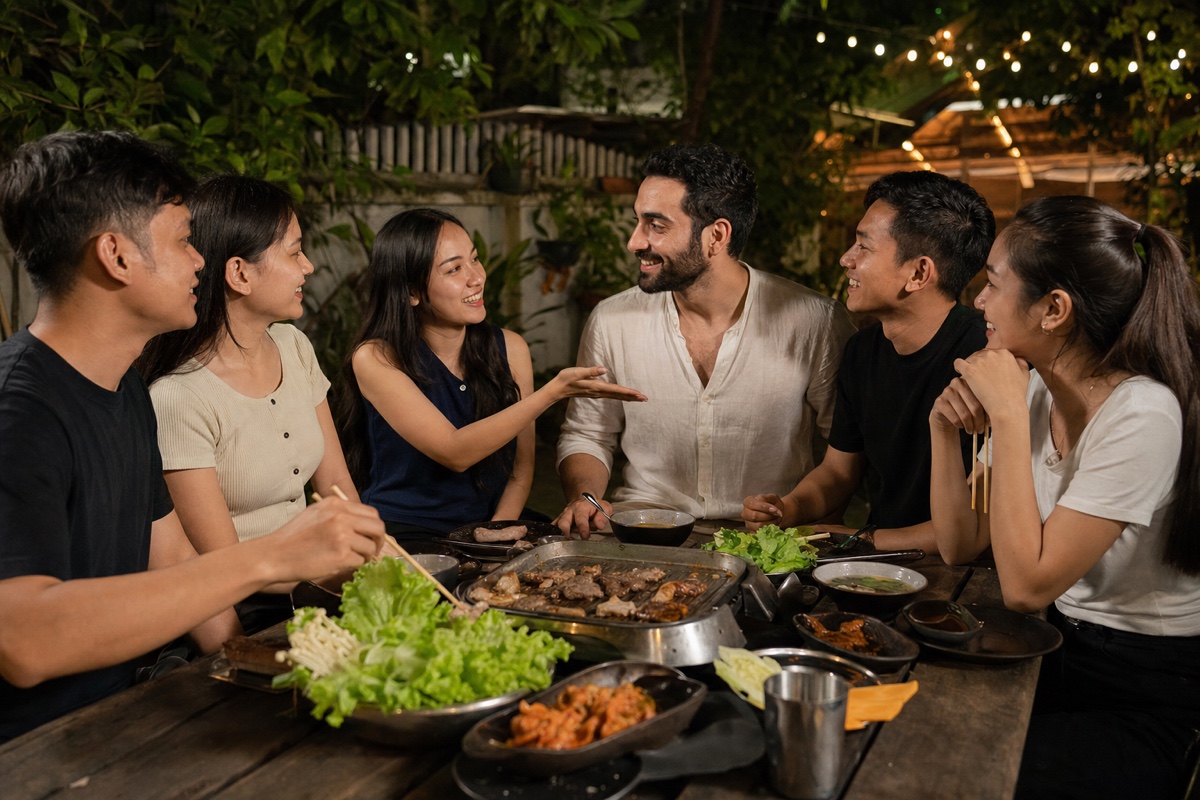 A Cambodian woman introducing a Middle Eastern foreign partner to a mixed group of Cambodian friends over grilled food